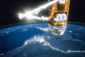 A satellite in space orbiting around the earth, equipped with advanced lighting systems.