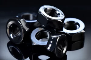 A group of black nuts and flat washer.